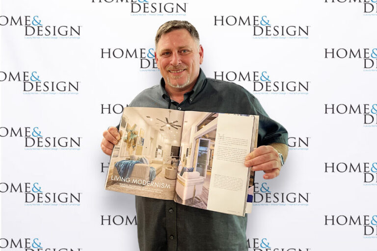 Man holding magazine in front of photo backdrop