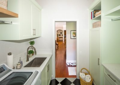Retro laundry room with green cabinets